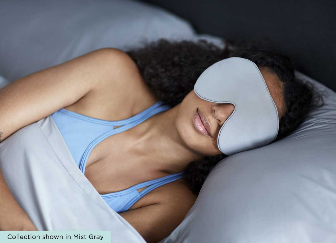 midnight label-sleep mask + travel pouch - mist gray color on model in bed #choose-your-color_porcelain